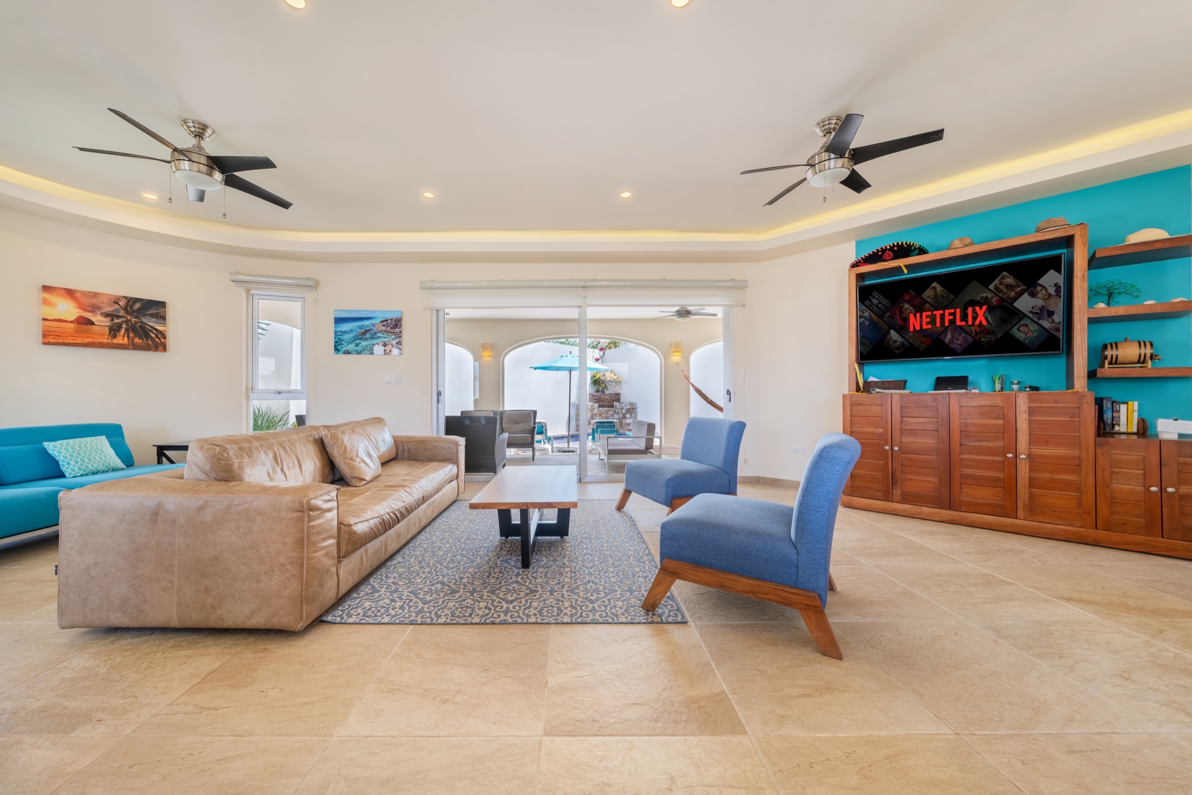Living room · leather sofa facing TV with blue accent chairs